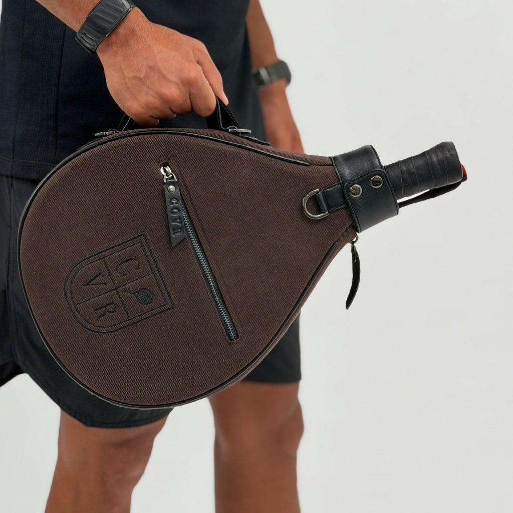 Coffee COVR padel racket cover carried by its handle