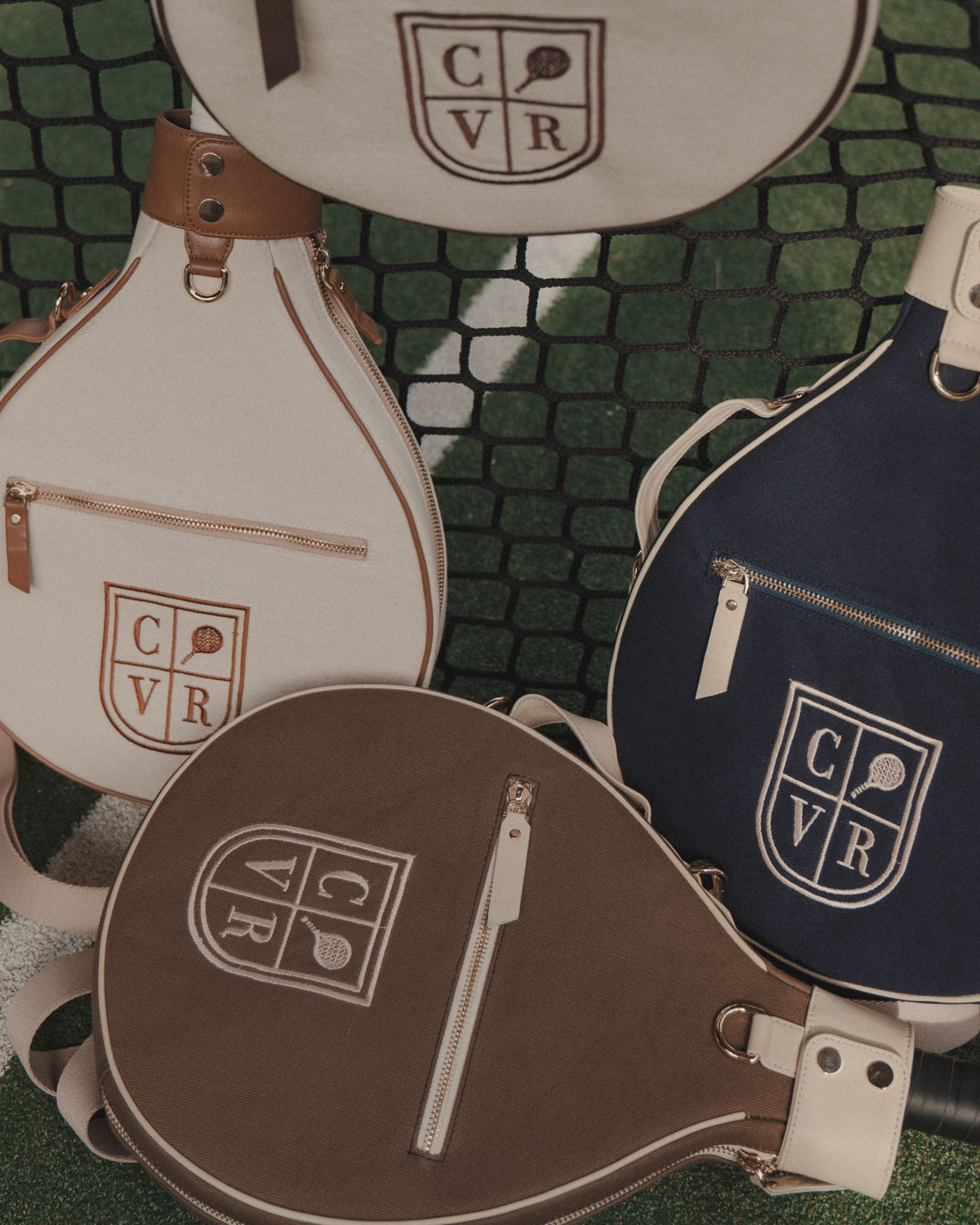 Cream, brown and navy COVR covers against a padel court net