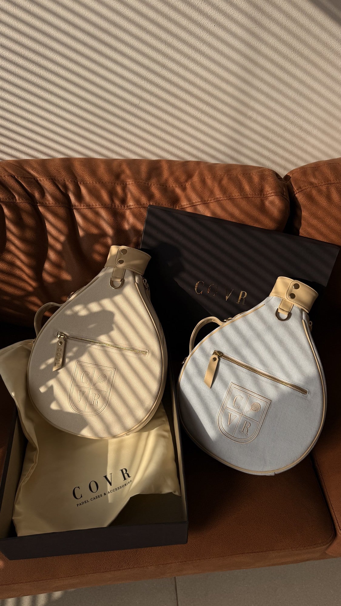 Two COVR covers in their gift box on a sofa in warm sunlight