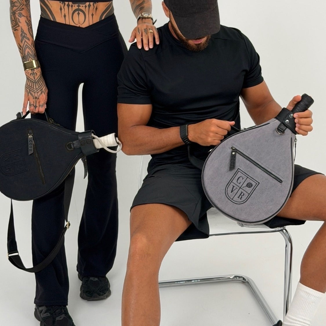 Two players with Total Black and Ash COVR padel racket covers